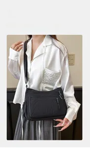 Détail du sac bandoulière en nylon noir imperméable avec compartiments zippés et sangle