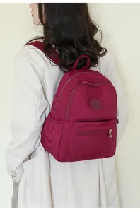 Burgundy water-resistant oxford nylon backpack shown on model for daily travel