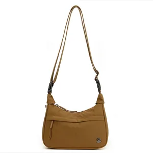 Brown nylon crescent crossbody bag with adjustable strap and metal logo on white background