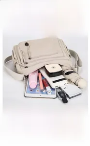 Détail des compartiments d'un sac bandoulière en nylon contenant iPad et accessoires