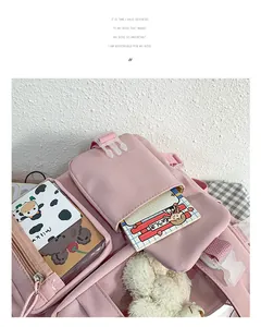 Detail eines rosa Oxford-Rucksacks mit mehreren Fächern und süßem Schulmaterial
