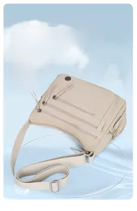 Détail du sac bandoulière en nylon imperméable avec plusieurs poches zippées sur podium