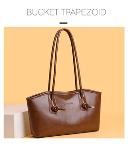 Détail du sac cabas en cuir marron avec bandoulière nouée et finitions métalliques