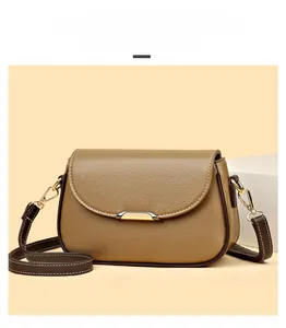 Detail view of brown lychee grain leather crossbody bag with elegant white topstitching