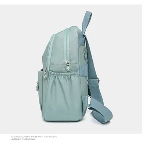 Side view of mint green nylon backpack showing waterproof material and multi-layer storage