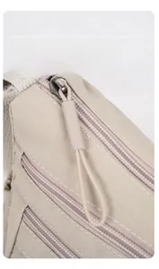 Détails du tissu en nylon et des poches à fermeture éclair sur le sac bandoulière beige