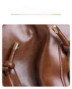Gros plan sur la texture du cuir caramel et les coutures précises du sac fourre-tout