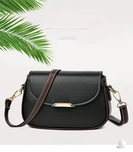 Detail of vintage crossbody bag with black pebble grain leather and golden metal buckle