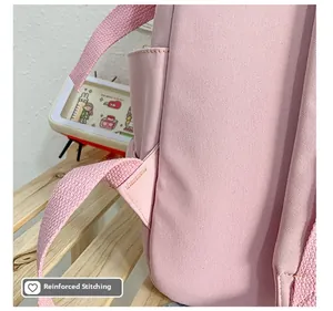 Detalle de las costuras triangulares reforzadas en las correas de la mochila de tela rosa