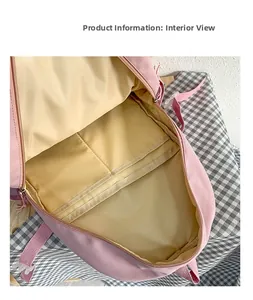 Vista interior de mochila oxford rosa con compartimentos amplios y forro amarillo