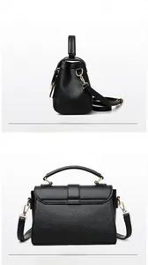 Detail view of black pebble leather texture and gold hardware hooks on a tote bag
