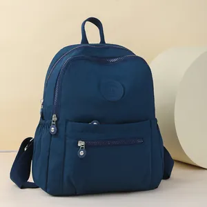 Navy blue oxford fabric travel backpack with multiple compartments and a front brand patch