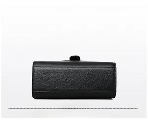 Detail showing the textured black leather bottom and durable stitching of the handbag