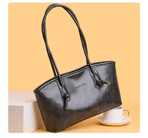 Détail des fines bretelles et du gaufrage FASHION & BAGS sur le sac fourre-tout noir