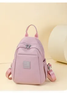 Détail du sac à dos rose en tissu oxford imperméable avec bretelles réglables et logo