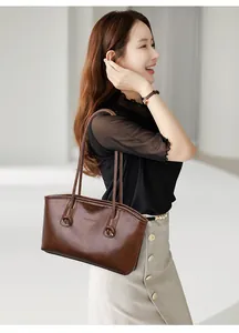 Détail du grand sac cabas marron porté à l'épaule avec texte gravé mode et sacs