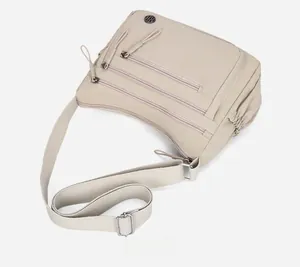 Détail d'un sac bandoulière beige en nylon avec poches zippées et bandoulière réglable