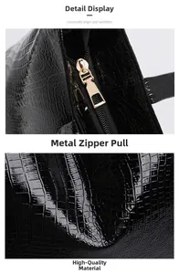 Details aus schwarzem Leder in Krokoprägung mit einem polierten goldenen Metallreißverschluss