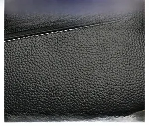 Detail of premium black lychee pattern leather with precise white stitching and zipper