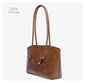 Vue latérale du sac fourre-tout marron caramel avec lanières nouées et détails dorés