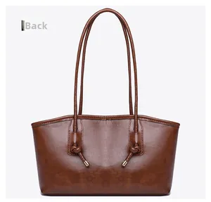 Vue arrière du sac cabas en cuir marron montrant les bretelles nouées et les embouts en métal