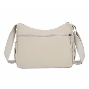 Waterproof nylon crossbody bag in beige with large capacity and adjustable wide shoulder strap