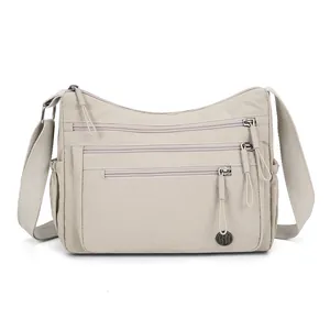 Sac à bandoulière en nylon imperméable avec plusieurs poches zippées et sangle large
