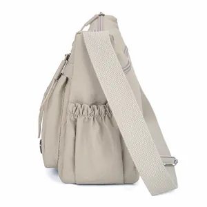 Waterproof khaki nylon crossbody bag with wide shoulder strap and side pocket