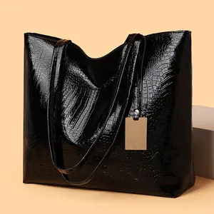 Elegante schwarze Tragetasche mit Krokodilmuster und glänzendem Gold-Metallanhänger