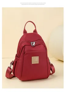 Gros plan du sac à dos en nylon rouge avec bretelles réglables et poches sur le côté