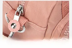 Close-up of pink nylon bag zipper and metal strap hook showing high-quality stitching
