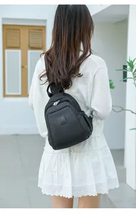 Détail du mini sac à dos en tissu Oxford noir avec fermeture éclair argentée et logo