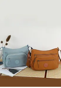 Detail of waterproof nylon crossbody bags with multiple zipper pockets and adjustable straps