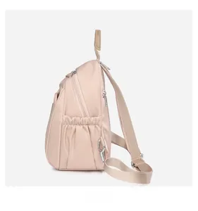 Détail d'un sac à dos en nylon kaki avec fermetures éclair multiples et poches latérales