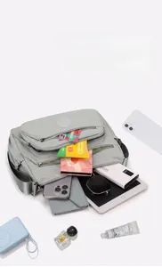 Detailed top view of light grey nylon crossbody bag showing large storage capacity for iPad