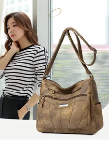 Detail view of multi-pocket brown PU leather crossbody bag with adjustable strap