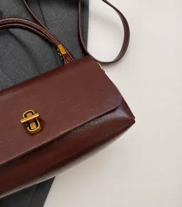 Nahaufnahme der dunkel rotbraunen Umhängetasche mit Vintage Faltenstruktur und Goldverschluss