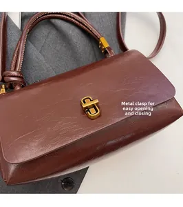 Nahaufnahme braune Vintage-Handtasche mit goldenem Schloss und verknotetem Griff
