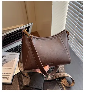 Détail du sac vintage en simili cuir marron foncé avec bandoulière tissée style ethnique