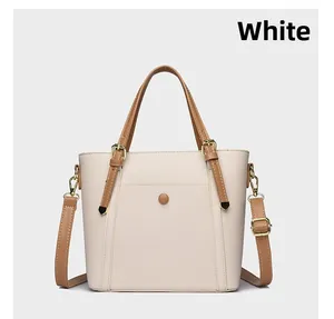 Detail of white lychee texture tote bag with brown straps and gold metal hardware