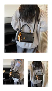 Schwarze Vintage Handtasche mit Metallschloss und dekorativer Holzperlen-Quaste