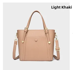 Detail view of light khaki tote bag featuring lychee grain texture and gold buckle hardware