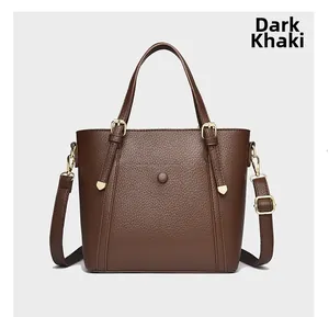 Detailed macro view of the dark khaki lychee grain texture and buckle on the tote bag