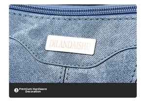 Close-up of textured grey-blue leather bag featuring a premium silver logo hardware plaque