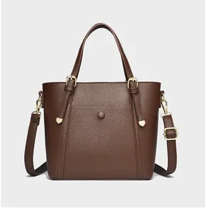 Close-up of brown litchi grain leather tote with gold hardware and stitching details