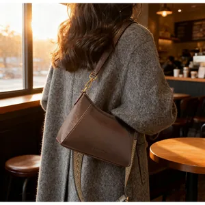 Détails du sac en cuir marron vintage avec texture et bandoulière en jacquard