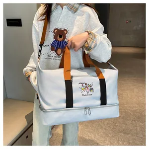 Light blue travel bag with orange straps and bottom shoe compartment shown on model