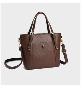 Detail of dark brown litchi grain tote bag with gold metal buckles and adjustable strap