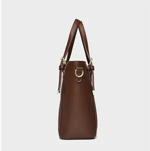 Detail shot of brown lychee grain leather tote bag with gold D-ring metal hardware