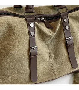 Detalle de bolsa de viaje en lona verde militar con acabados de cuero y hebilla metálica
